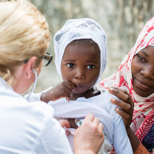 Doctor assisting child during volunteer work, operation smile, charity, Global Smile